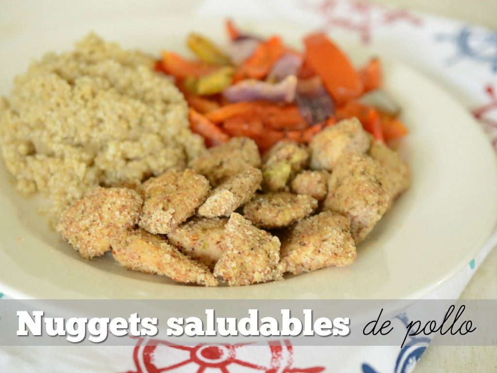 Nuggets saludables de pollo servidos en un plato blanco con quinoa y vegetales.