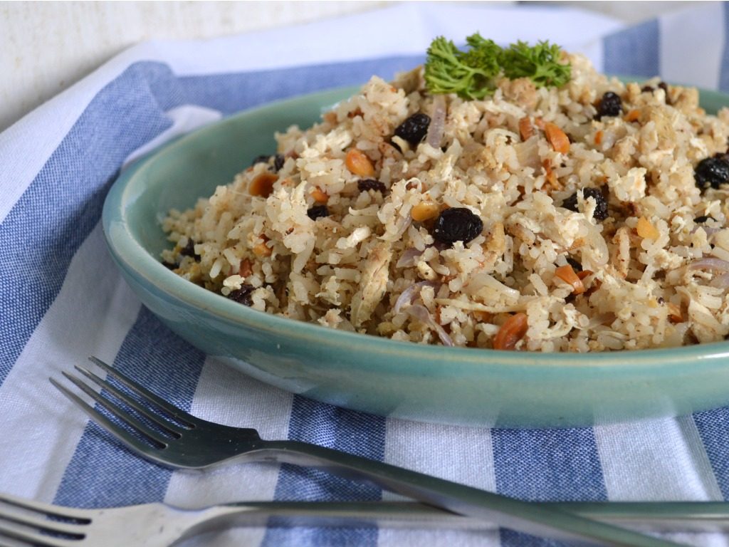 Plato azul de arroz árabe de almendras con un par de tenedores.