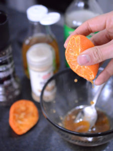 Toma en primer plano de una mano exprimiendo una mandarina.